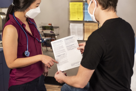 A person discussing a document with a doctor