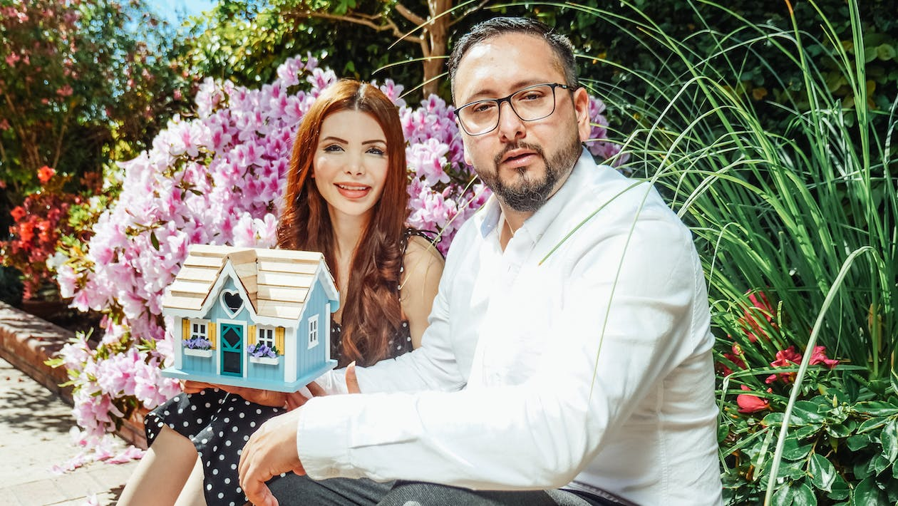 A couple holding a miniature home 